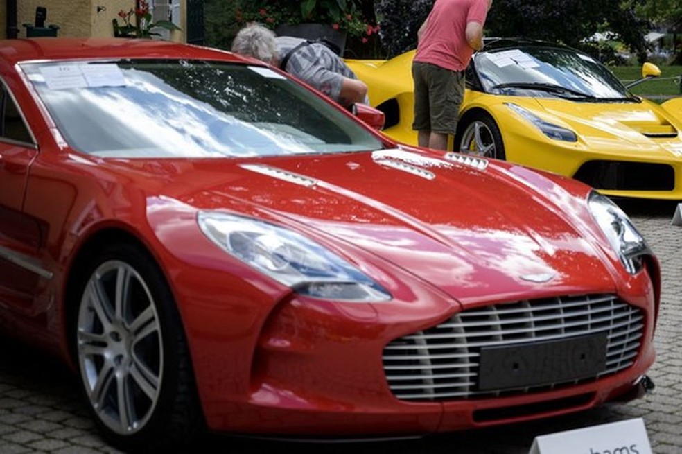 Este Aston Martin One-77 Coupe (vermelho, a frente) foi feito à mão (Foto: Reuters) — Foto: Auto Esporte