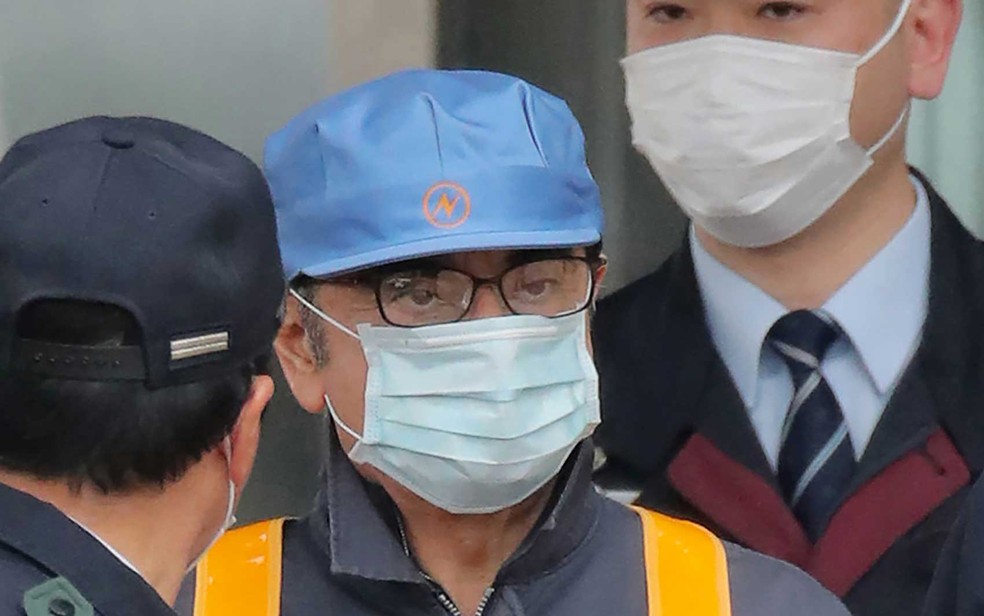 O ex-presidente da Nissan, Carlos Ghosn deixa a Casa de Detenção de Tóquio usando uma máscara — Foto: Jiji Press / AFP Photo