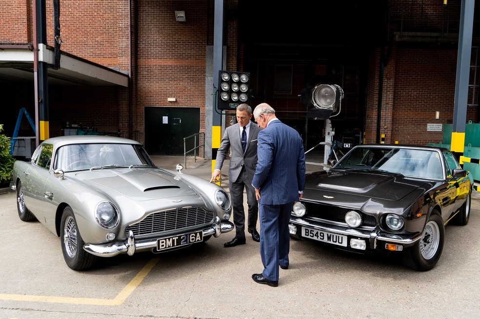 Daniel Craig e o então Príncipe Charles com os carros do filme 007 - Sem Tempo para Morrer — Foto: Divulgação