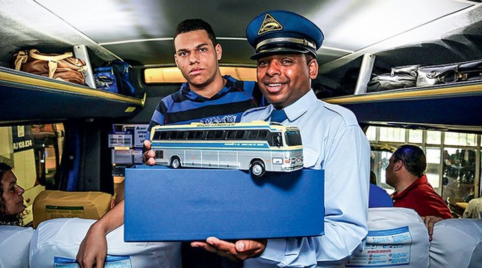 O busólogo Fábio recebeu do motorista Ernesto a pequena réplica do Flecha Azul; uma da série de65 feitas para a despedida (Foto: Rafael Munhoz/Auto News Brasil) — Foto: Auto Esporte