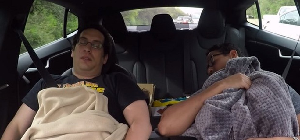 Dois jovens dormindo enquanto o piloto automático do Tesla Model S dirige na estrada (Foto: Reprodução/Youtube) — Foto: Auto Esporte