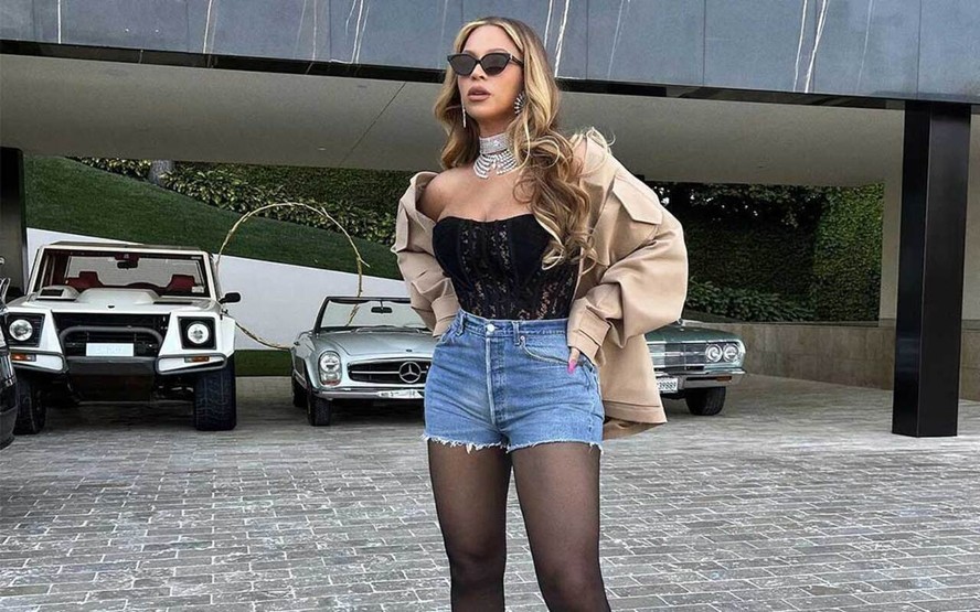 Beyoncé na frente de parte da sua coleção de carros