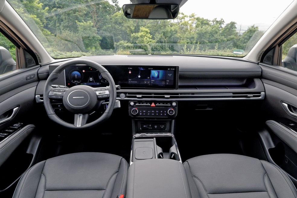Telas digitais integradas entre si e destacadas do painel chamam a atenção na cabine do Tucson PHEV — Foto: Divulgação