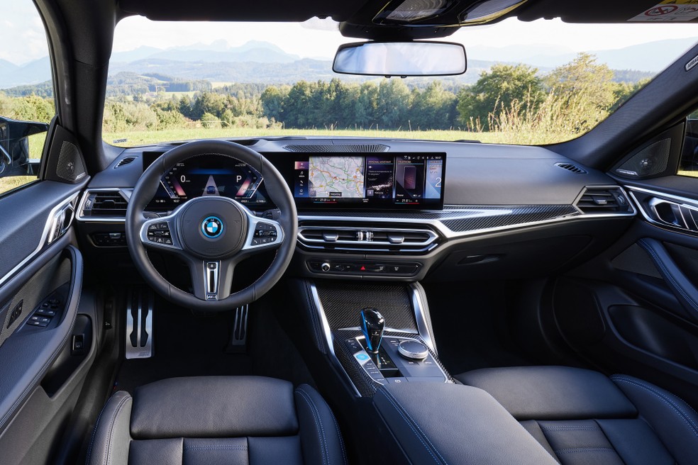 Interior do BMW i4 traz a tela curva que abrange o painel de instrumentos e a central multimídia — Foto: Divulgação