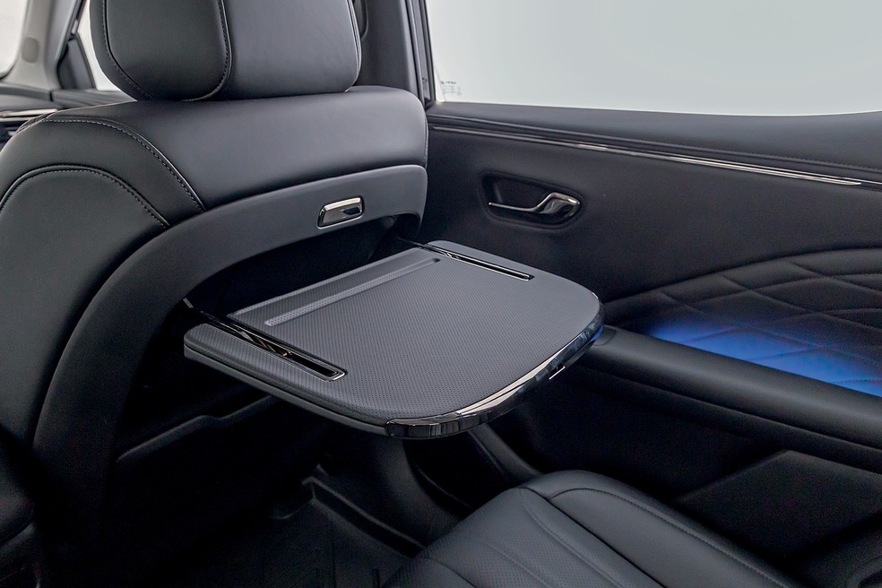 GAC Aion V Elite tem plástico emborrachado e couro no acabamento; mesinha ainda garante comodidade para os ocupantes — Foto: Renato Durães/Auto News Brasil