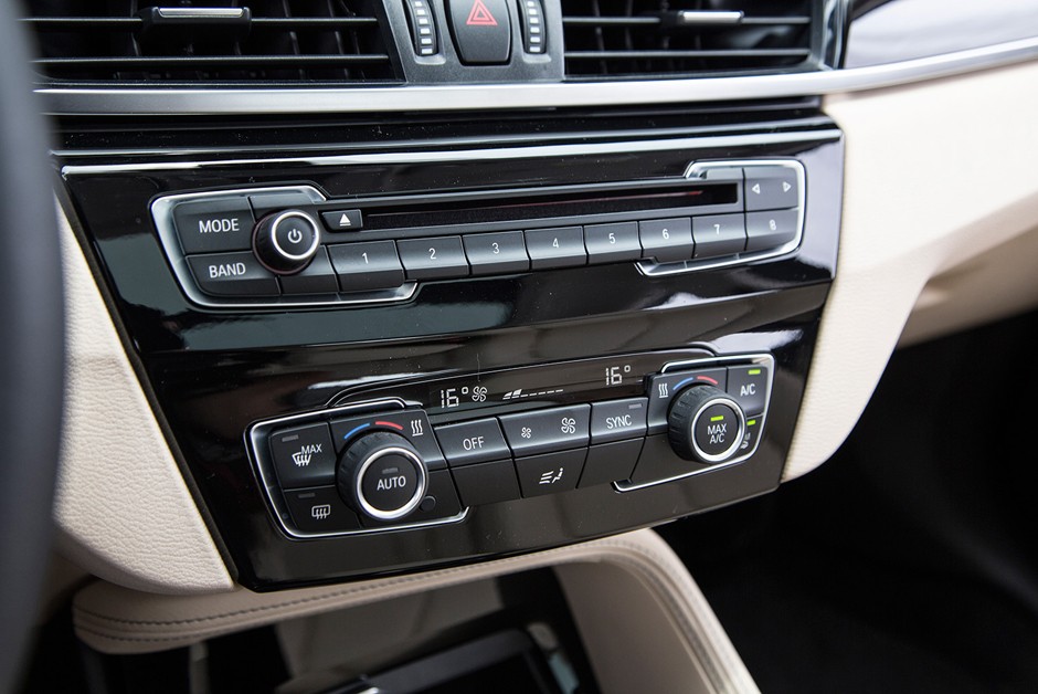 Detalhe dos comandos do rádio e do ar-condicionado do BMW X1 sDrive20i