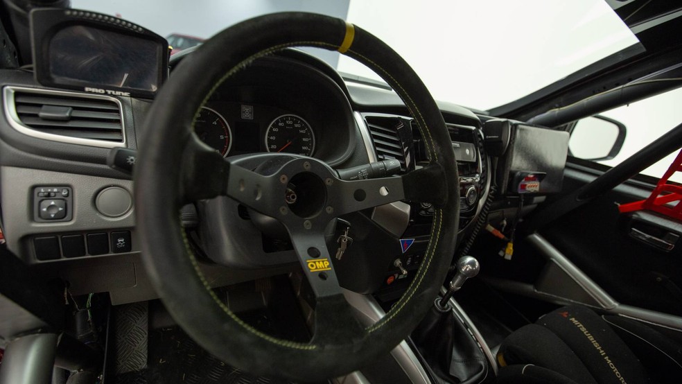 O interior mantém o painel, mas perde a maior parte dos acabamentos e equipamentos do carro de rua — Foto: Divulgação