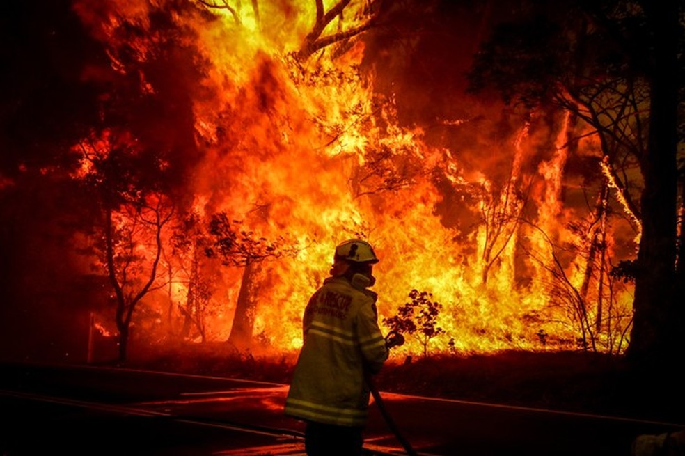 Bombeiro tenta controlar as chamas em uma floresta australiana (Foto: Getty Images) — Foto: Auto Esporte