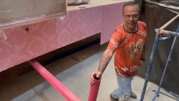 Diretor de barracão da Rosas de Ouro demonstra o funcionamento do cambão, o "volante" do carro alegórico — Foto: Cauê Lira/Auto News Brasil